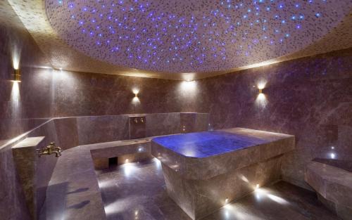 a bathroom with a large tub with a purple ceiling at DoubleTree by Hilton Almaty in Almaty