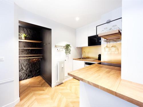 une cuisine avec des armoires blanches et un plancher en bois dans l'établissement Le Petit Luxe - hypercentre, cinéma, king size, à Troyes