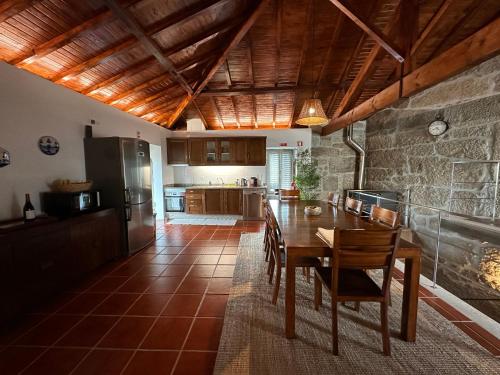 cocina y comedor con mesa y sillas en Casa da Clarinha, en Penalva do Castelo