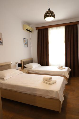 2 Betten in einem Hotelzimmer mit Fenster in der Unterkunft Daniel City Center Apartment in Berat
