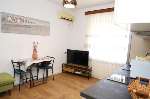 Una sala de estar con una mesa y un televisor. en Daniel City Center Apartment, en Berat