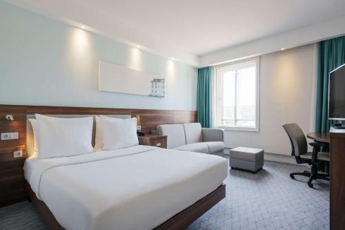 Habitación de hotel con cama grande y escritorio. en Hampton by Hilton Amsterdam Centre East, en Ámsterdam