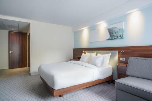 une chambre d'hôtel avec un lit et une chaise dans l'établissement Hampton by Hilton Amsterdam Centre East, à Amsterdam