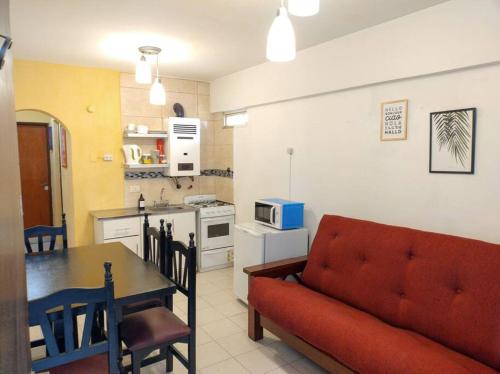 ein Wohnzimmer mit einem Sofa und einem Tisch sowie eine Küche in der Unterkunft Grandioso 2 en Barrio Sur in San Miguel de Tucumán