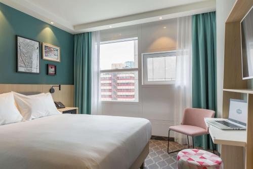 um quarto de hotel com uma cama, uma secretária e um computador portátil em Hampton By Hilton Utrecht Centraal Station em Utrecht