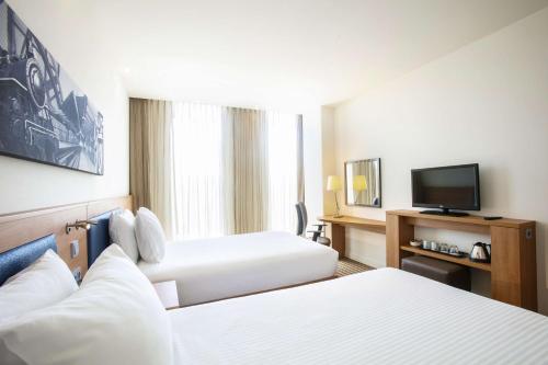 a hotel room with two beds and a flat screen tv at Hampton By Hilton Amsterdam Arena Boulevard in Amsterdam