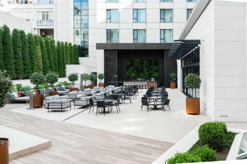 a patio with tables and chairs in front of a building at Hilton Belgrade in Belgrade