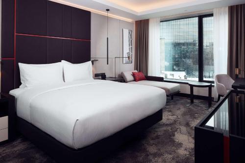 a bedroom with a large white bed and a desk at Hilton Belgrade in Belgrade
