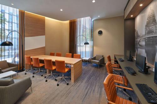 a conference room with a wooden table and chairs at Hampton by Hilton Berlin City Centre Alexanderplatz in Berlin