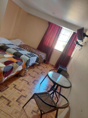 1 dormitorio con 1 cama, mesa y sillas en Hotel San Pedro de Palpas, en Churín