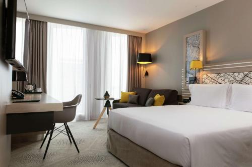 Habitación de hotel con cama y escritorio en Hilton Garden Inn Bordeaux Centre en Burdeos