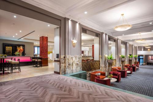 a lobby of a hotel with red chairs and tables at DoubleTree By Hilton Brussels City in Brussels