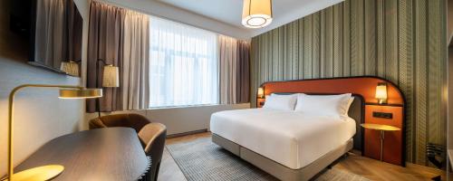 um quarto de hotel com uma cama e uma secretária em DoubleTree By Hilton Brussels City em Bruxelas