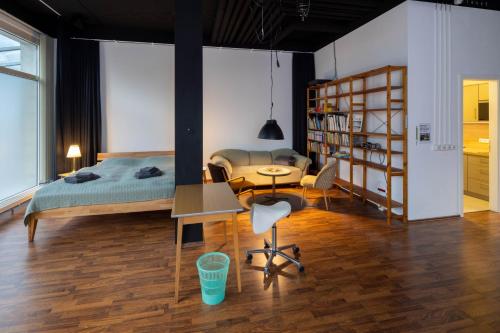een slaapkamer met een bed, een bureau en een tafel bij Studioatelier in Übigau in Dresden