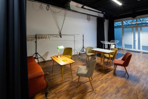 a room with chairs and tables and a lamp on a table at Studioatelier in Übigau in Dresden