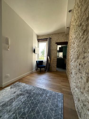 uma sala de estar com uma parede de pedra e uma cadeira em Appartement calme design et Comfort em Orléans