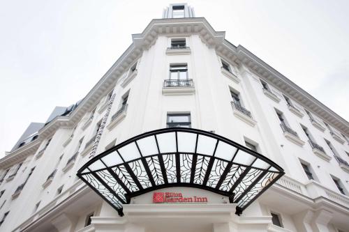 un edificio blanco alto con un letrero. en Hilton Garden Inn Bucharest Old Town en Bucarest