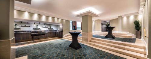 a lobby of a hotel with a table and a counter at Hilton Brussels Grand Place in Brussels