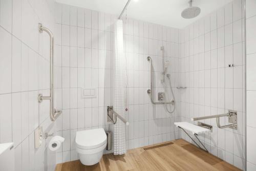 La salle de bains est pourvue d'une douche et de toilettes. dans l'établissement Hilton Garden Inn Bucharest Airport, à Otopeni