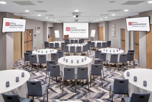 a conference room with white tables and chairs at Hilton Garden Inn Bucharest Airport in Otopeni