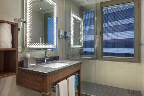 a bathroom with a sink and a mirror at Hampton By Hilton Bursa in Bursa