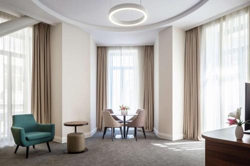 a room with chairs and a table and windows at Hilton Garden Inn Bucharest Old Town in Bucharest