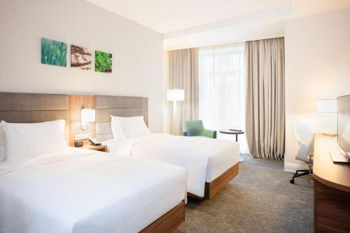 a hotel room with two beds and a desk at Hilton Garden Inn Bucharest Old Town in Bucharest