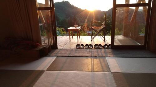 Cette chambre dispose d'une porte s'ouvrant sur une terrasse avec une table. dans l'établissement Open-air bath in the sky Yomogi House - Vacation STAY 93125v, à Tōkamachi