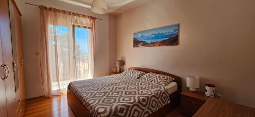 a bedroom with a bed and a large window at Holiday Apartment Arman in Vižinada