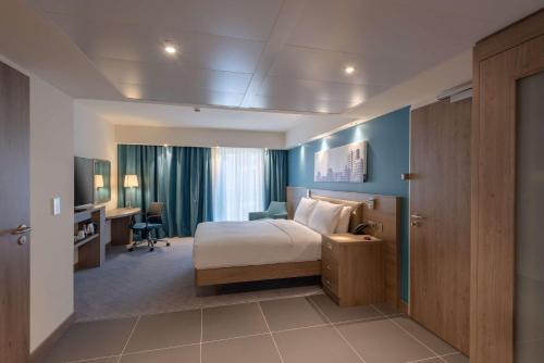 ein Hotelzimmer mit einem Bett und einem Schreibtisch in der Unterkunft Hampton by Hilton Düsseldorf City Centre in Düsseldorf