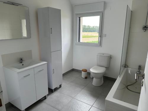 une salle de bain avec toilettes, lavabo et fenêtre dans l'établissement Maison avec Jacuzzi 1-8 pers à 10 mn de st Malo, à Saint-Méloir-des-Ondes