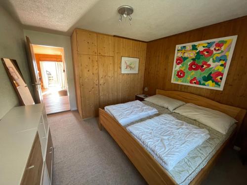 ein Schlafzimmer mit einem Bett und einem Wandgemälde in der Unterkunft Lescha C2C in Sarn