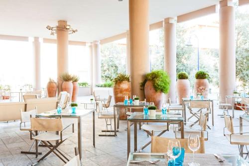 un ristorante con tavoli, sedie e ampie finestre di Hilton Garden Inn Florence Novoli a Firenze