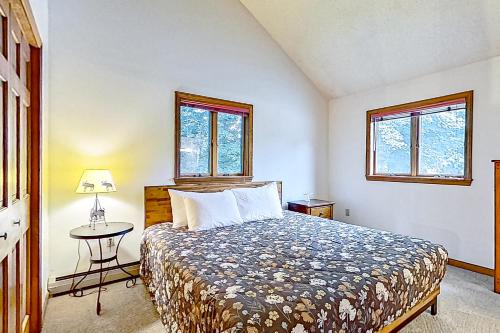 - une chambre avec un lit, une table et deux fenêtres dans l'établissement Eagle Ridge House, à Bartlett