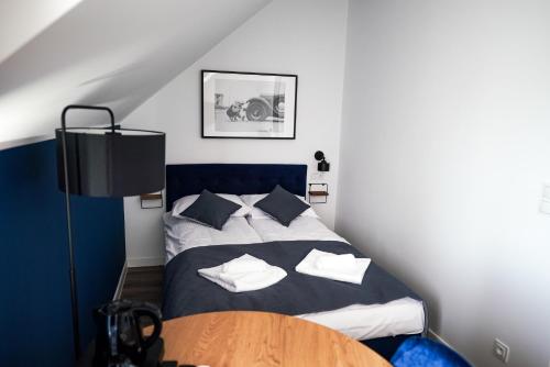 a bedroom with a bed with pillows and a table at La Familia TYBURA in Uniejow