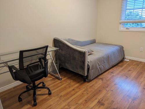 a bedroom with a bed and a desk and a chair at Adorable 4 bed,3 bath house in Kingston