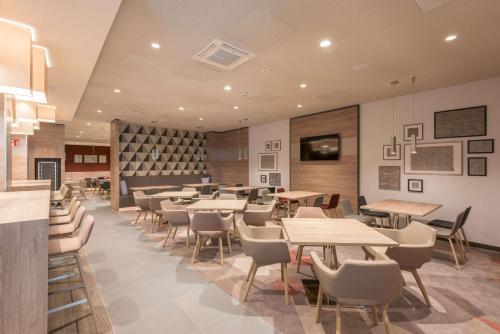 a restaurant with tables and chairs in a room at Hampton By Hilton Frankfurt City Centre East in Frankfurt