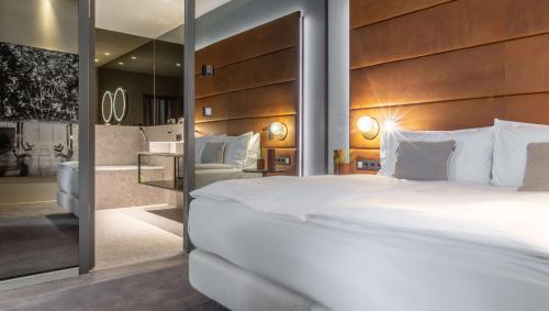 een slaapkamer met een groot wit bed en een spiegel bij Hilton Garden Inn Mannheim in Mannheim