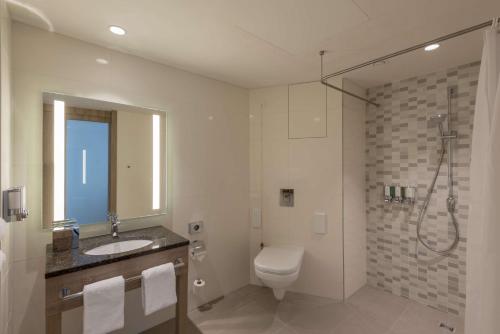 a bathroom with a toilet and a sink and a shower at Hampton By Hilton Frankfurt City Centre East in Frankfurt