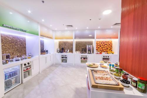 a large kitchen with a counter with food on it at Hampton By Hilton Iasi in Iaşi