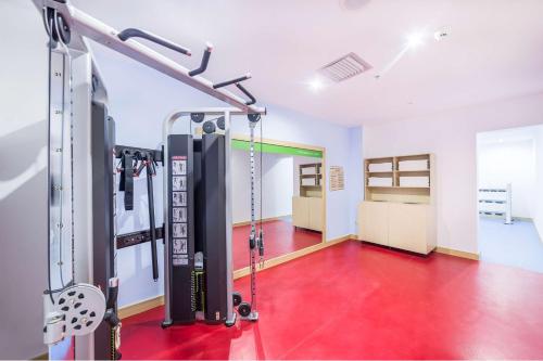 a gym with a red floor and a treadmill at Hampton By Hilton Iasi in Iaşi
