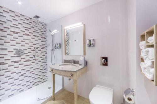 a bathroom with a sink and a toilet and a mirror at Hampton By Hilton Iasi in Iaşi