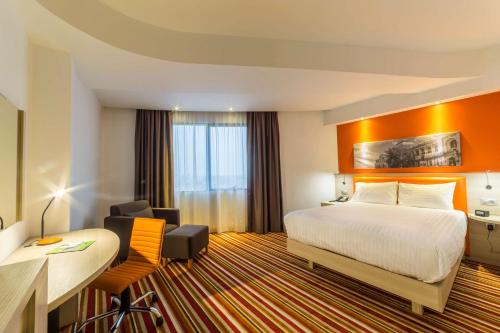 a hotel room with a bed and a desk at Hampton By Hilton Iasi in Iaşi