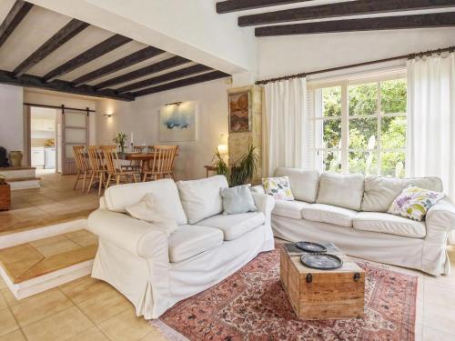 a living room with white couches and a table at Belvilla by OYO Blu Marine in Font de Sa Cala