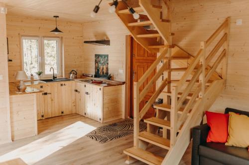 uma cozinha com uma escada de madeira num chalé de madeira em Domek na skarpie em Joniec