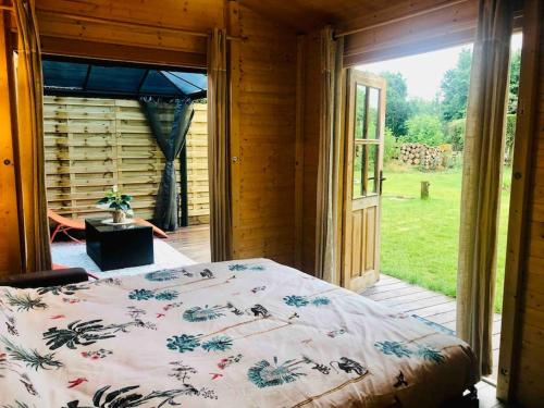 a bedroom with a bed and a large window at Tiny House Close to Brussels South Charleroi Airport in Courcelles