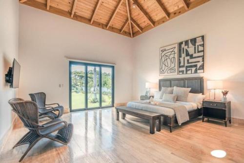 een woonkamer met een bed en een stoel bij Sunny Vacation Villa No 73 in San Rafael del Yuma