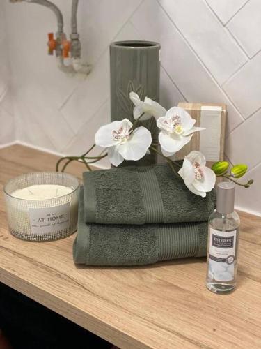 une pile de serviettes et un vase avec des fleurs sur un comptoir dans l'établissement Charming Flat in Montmartre - Imhost, à Paris