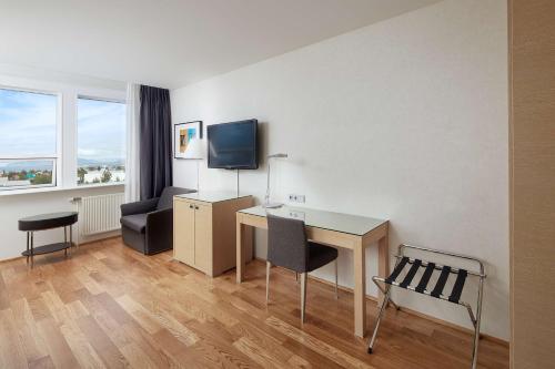a hotel room with a desk and a chair at Hilton Reykjavik Nordica in Reykjavík