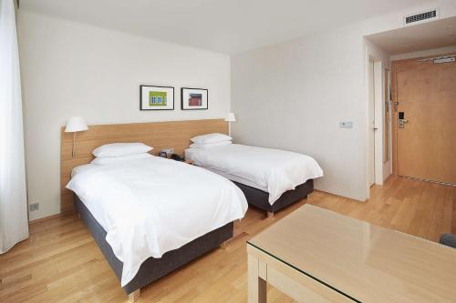 a hotel room with two beds and a table at Hilton Reykjavik Nordica in Reykjavík